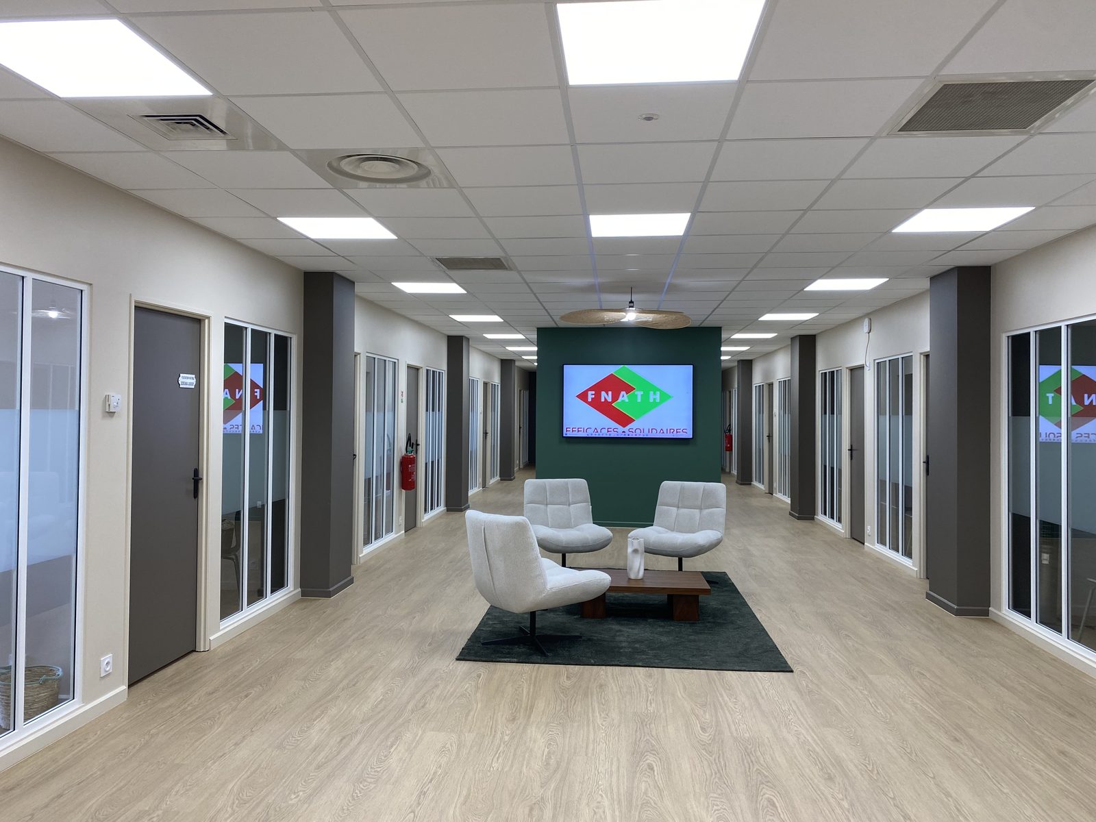 Bureaux 400 m² après travaux : plateau aménagé, éclairage LED, faux-plafond et sol stratifié