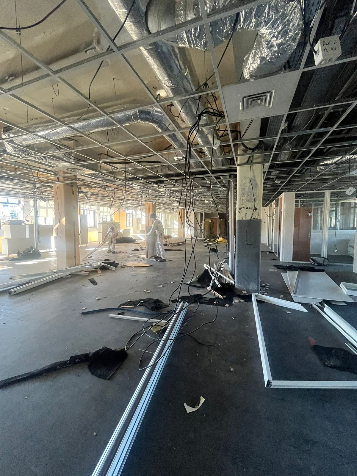 Aménagement de bureaux 400 m² pendant les travaux : dépose du faux-plafond, réseaux électriques et VMC apparents